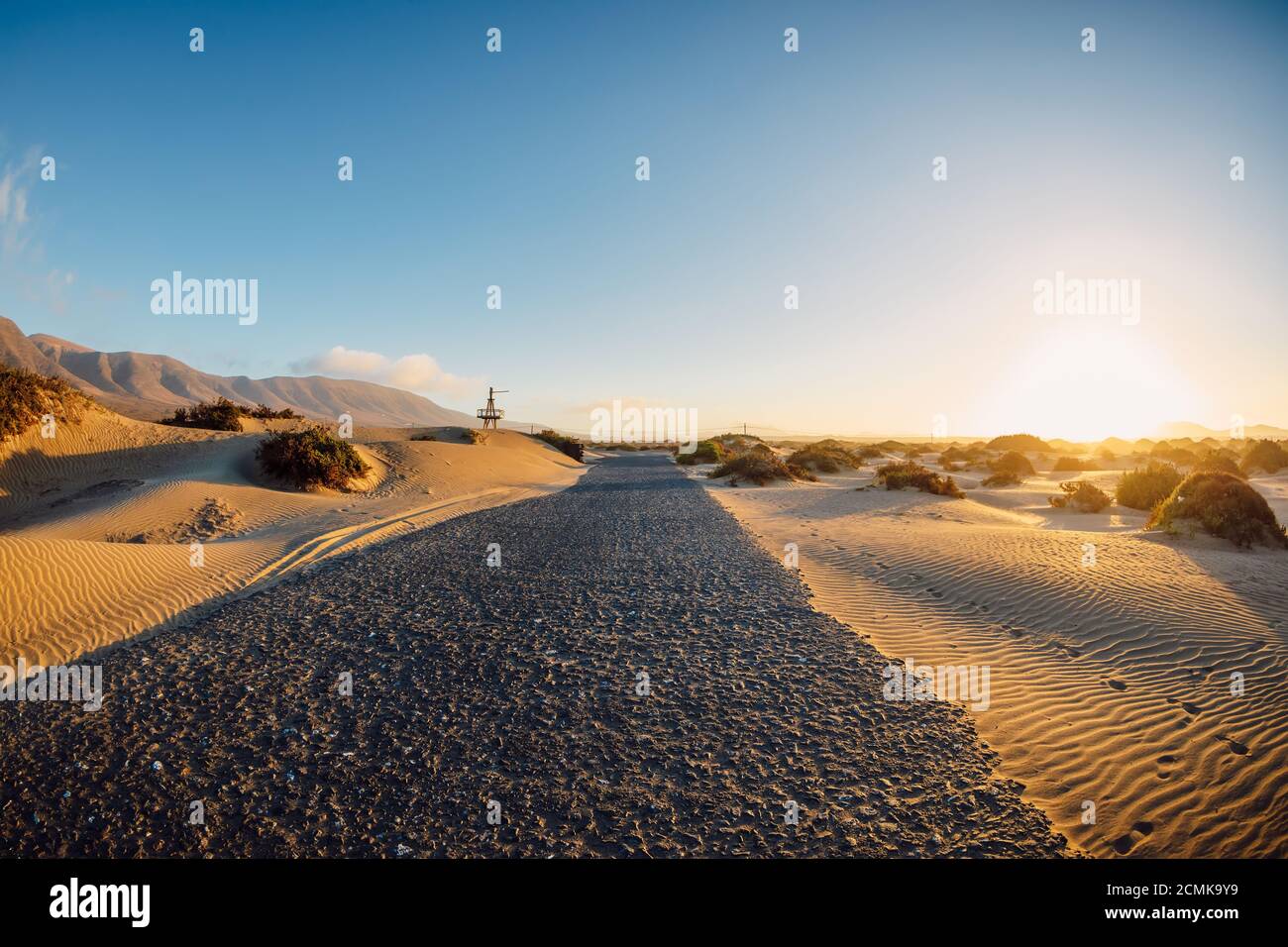 Sanddünen mit Straße bei Sonnenuntergang in Famara Strand, Lanzarote Spanien. Stockfoto