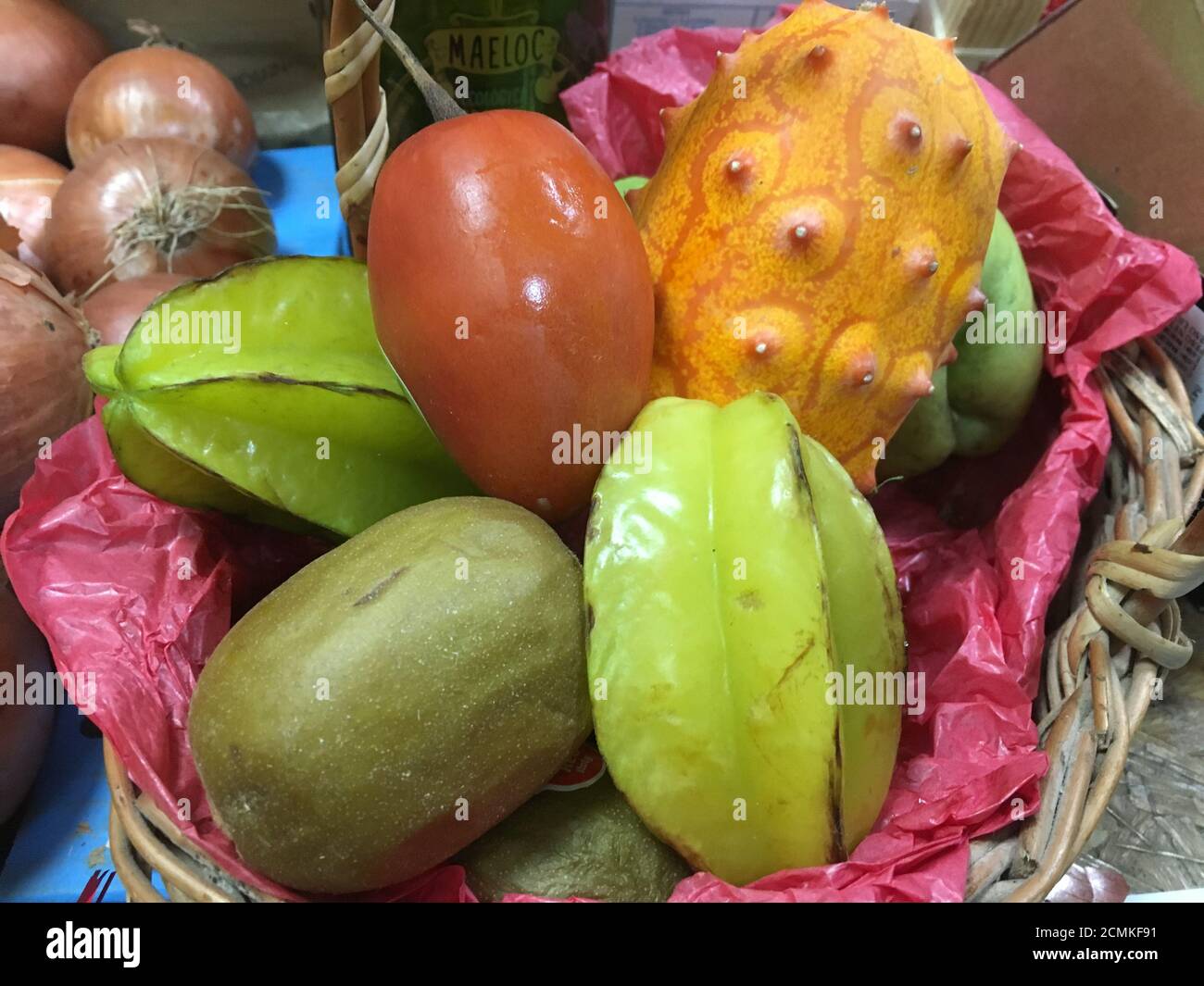 Tropische Früchte in einem Korb zum Verkauf Stockfoto