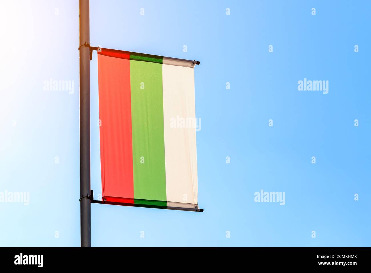 Flagge Bulgariens an einem sonnigen Tag gegen einen klaren blauen Himmel. Bulgarische Flagge hinten beleuchtet mit Sonnenlicht. Stockfoto