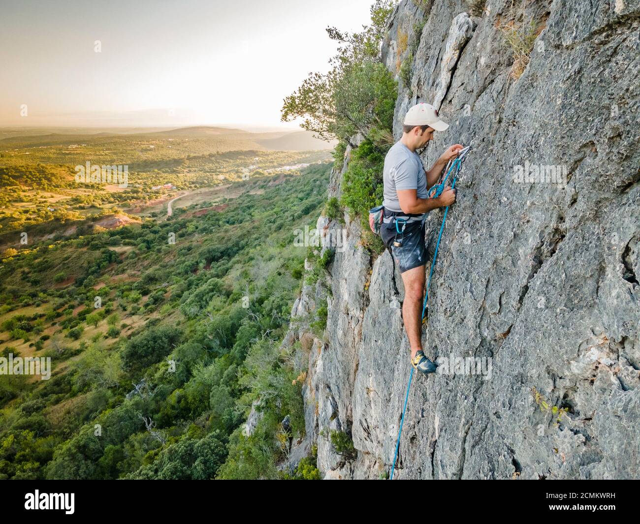 Mann, der einen steilen, schlichten Felsen in Portugal klettert Stockfoto