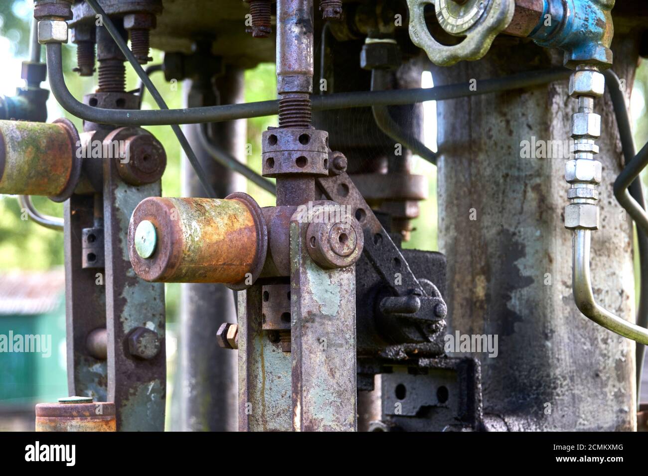 Ventile, Anschlüsse, Armaturen und Lenkräder an einer alten mechanischen Pumpe Stockfoto