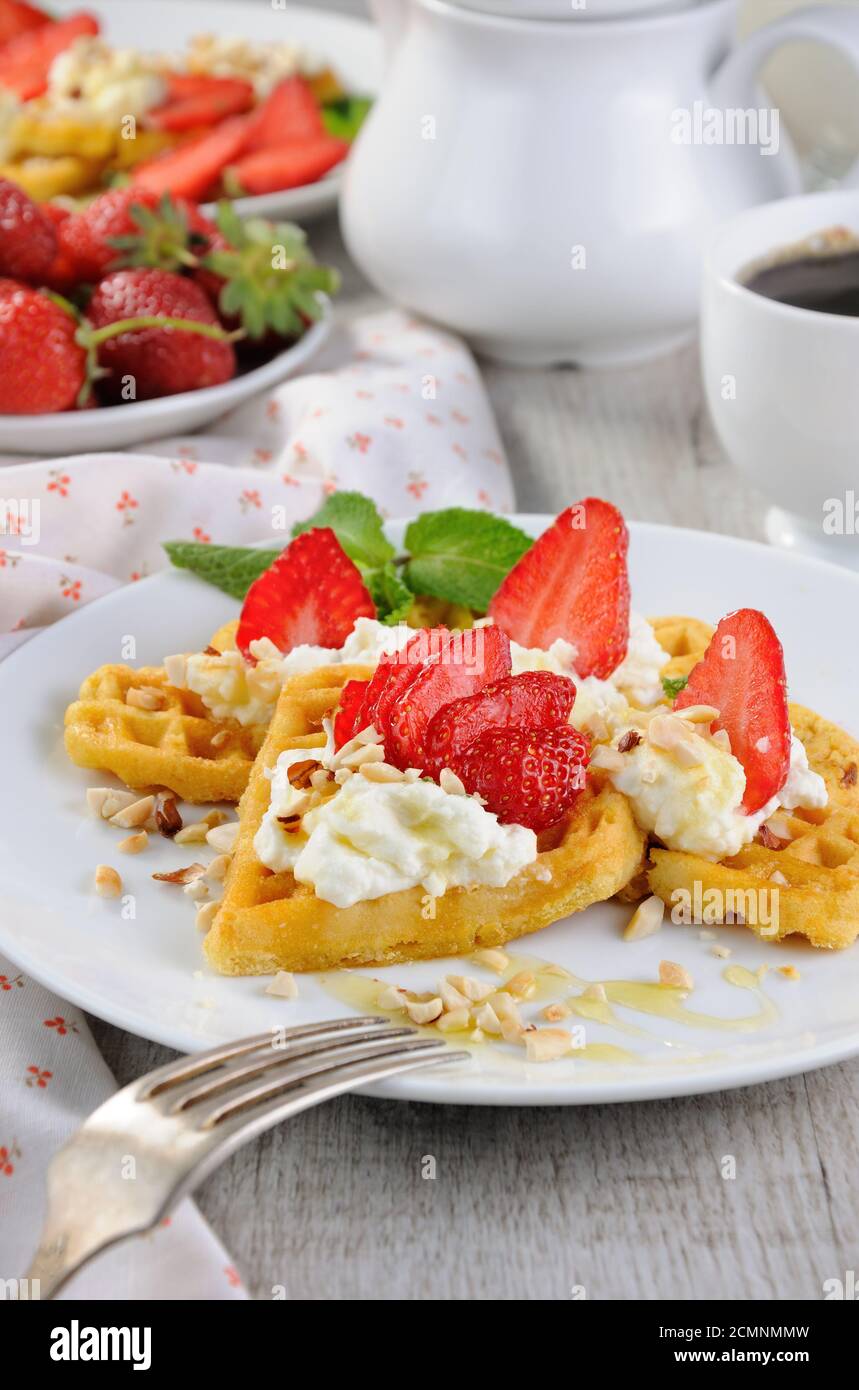 Delikate, köstliche belgische Waffeln mit Schlagsahne, Erdbeeren, aromatisiert mit p Stockfoto
