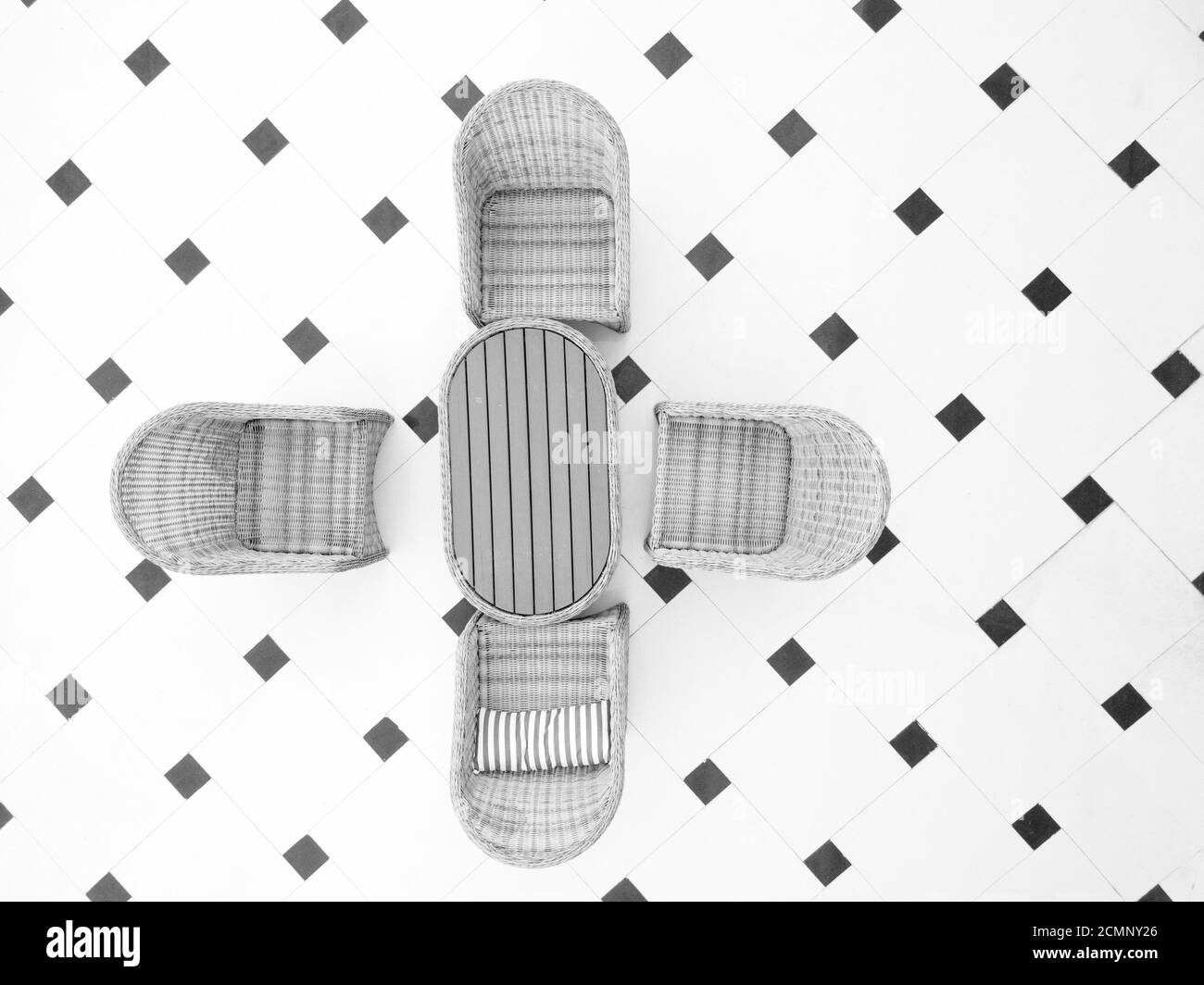 Deckenaufnahme eines Terrassenmöbels auf dem gefliesten Boden, in schwarz und weiß Stockfoto