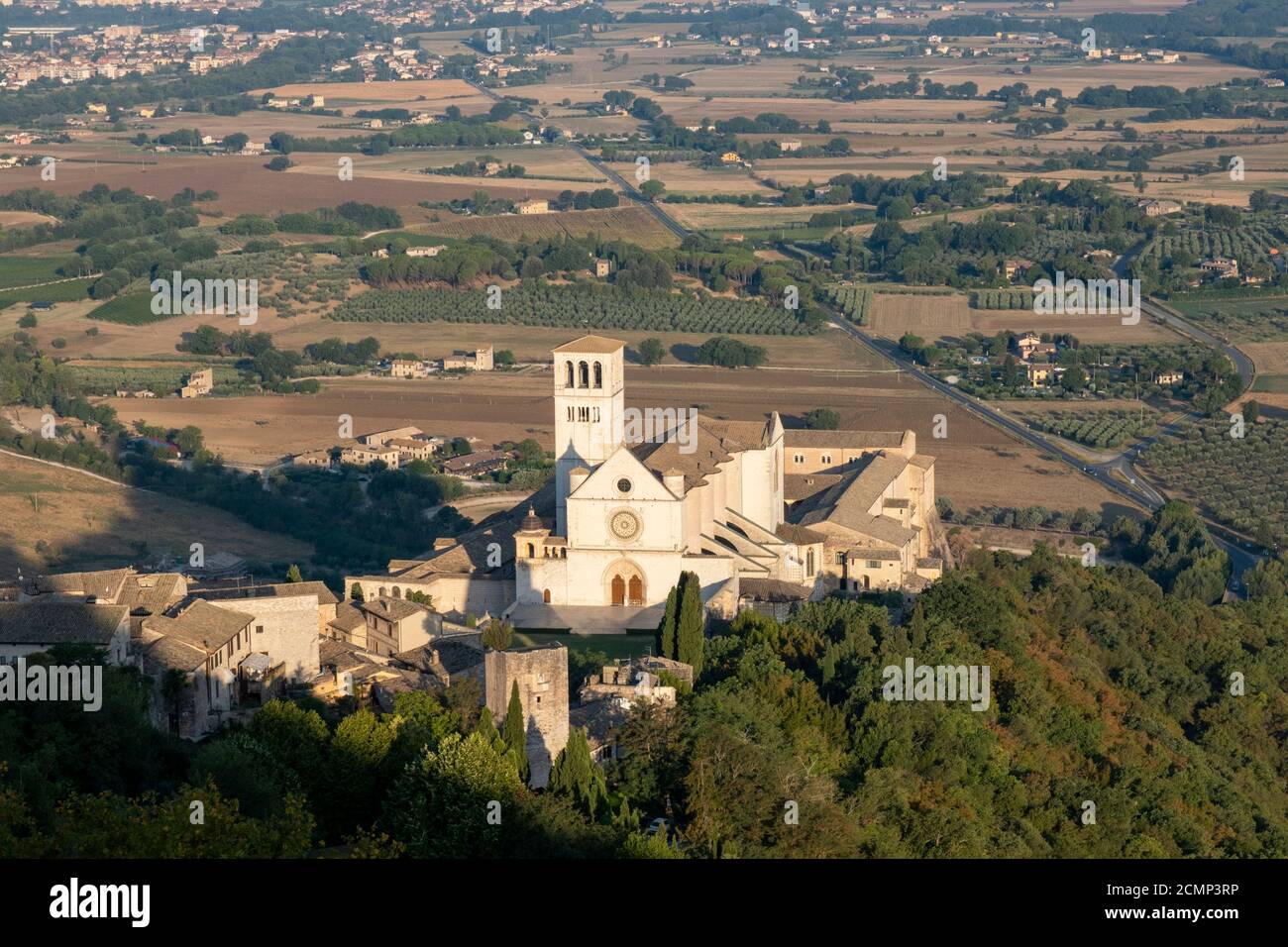 Basilika des Heiligen Franziskus von Assisi, Basilika Papale di San Francesco, mit Statue bei Sonnenaufgang in Assisi, Umbrien, Italien Stockfoto