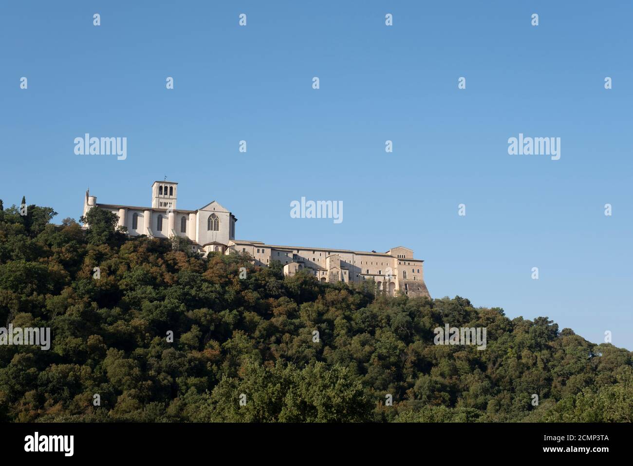 Basilika des Heiligen Franziskus von Assisi, Basilika Papale di San Francesco, mit Statue bei Sonnenaufgang in Assisi, Umbrien, Italien Stockfoto