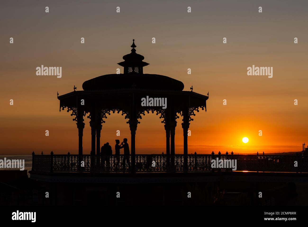 Paare tanzen bei Sonnenuntergang im viktorianischen Bandstand bekannt als Birdcage, auf Kings Road, Brighton. Ungeschliffen Stockfoto