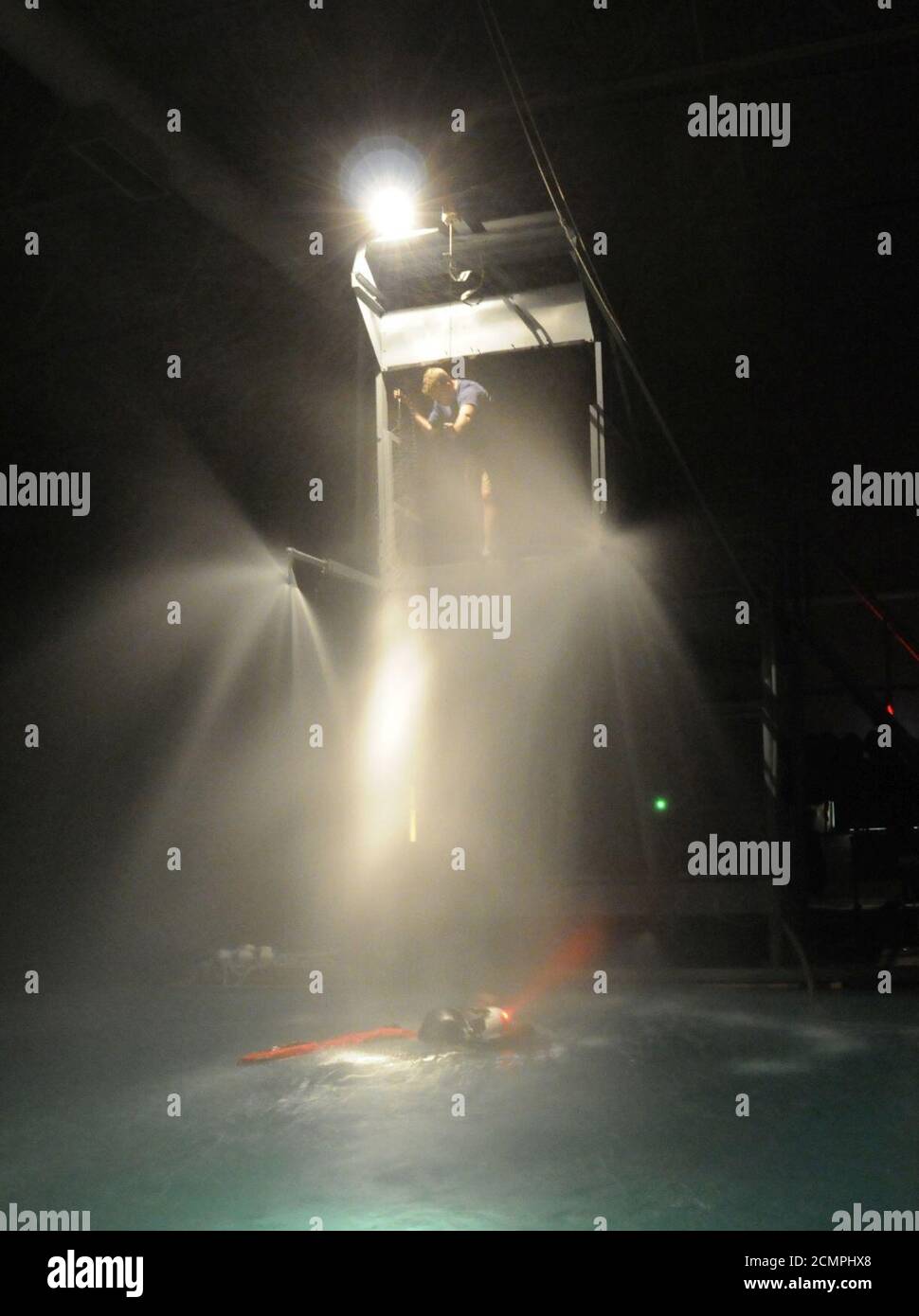 Navy Diver 1. Klasse ein Instruktor am Aviation Survival Training Kurs, senkt einen Hebezeug zu einem Schüler. Stockfoto