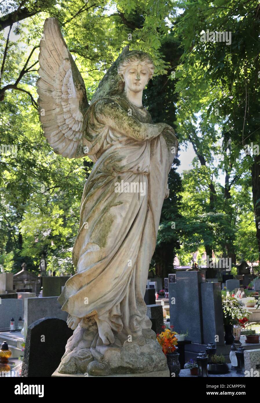 Krakau. Krakau. Polen. Rakowicki Friedhof. Eine steinerne geschnitzte Statue eines Engels, der auf dem Grab steht. Stockfoto