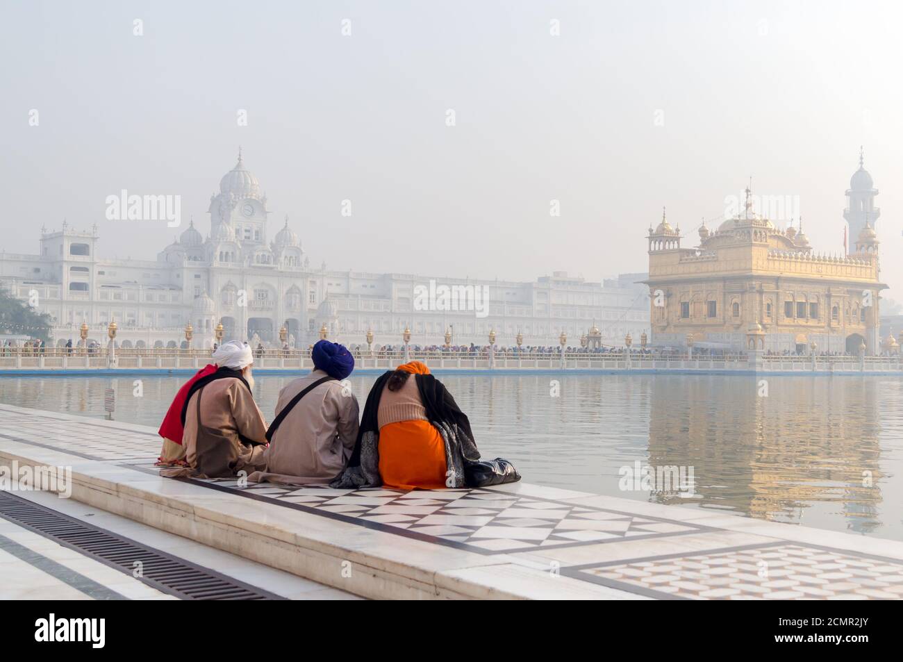 Amritsar, Indien - 21. November 2011: Die Sikh-Pilger meditieren auf dem Amrit Sarovar See im Golden Temple Complex. Amritsar, Punjab, Indien. Stockfoto