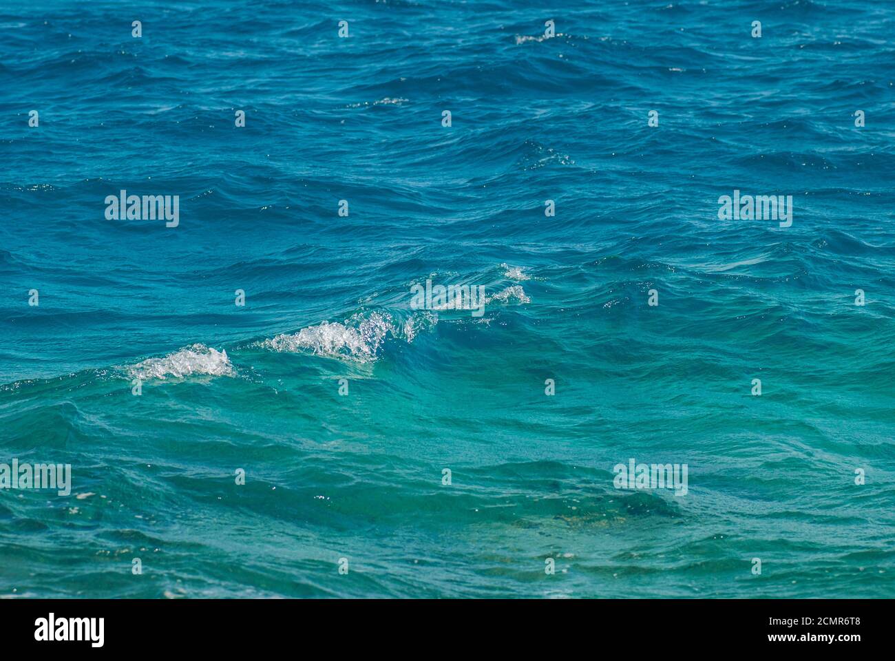 Breite Aufnahme einer schönen klaren türkisfarbenen Meer Ozean Wasseroberfläche mit niedrigen Wellen und subtilen Wellen auf Meeresgrund, horiz Stockfoto