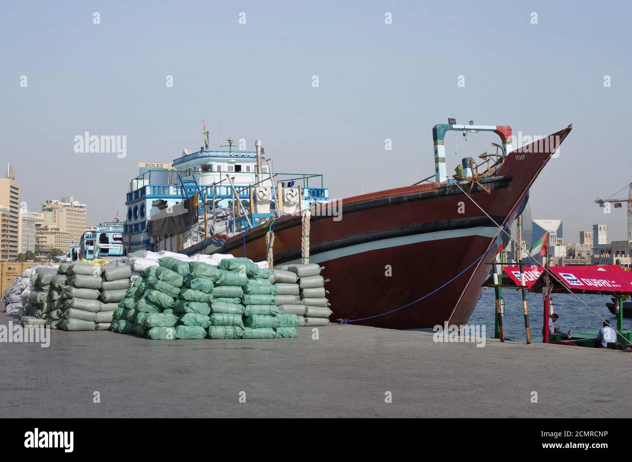 Ein kleines privates No Name Handelsschiff lädt Taschen mit Baumwolle auf dem Liegeplatz. Stockfoto