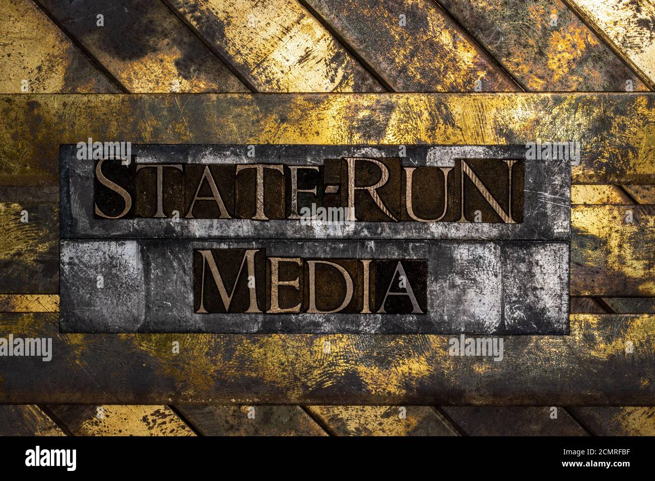 State-Run-Medien-Text mit echten authentischen Satzbuchstaben auf gebildet Vintage strukturierte Silber Grunge Kupfer und Gold Hintergrund Stockfoto