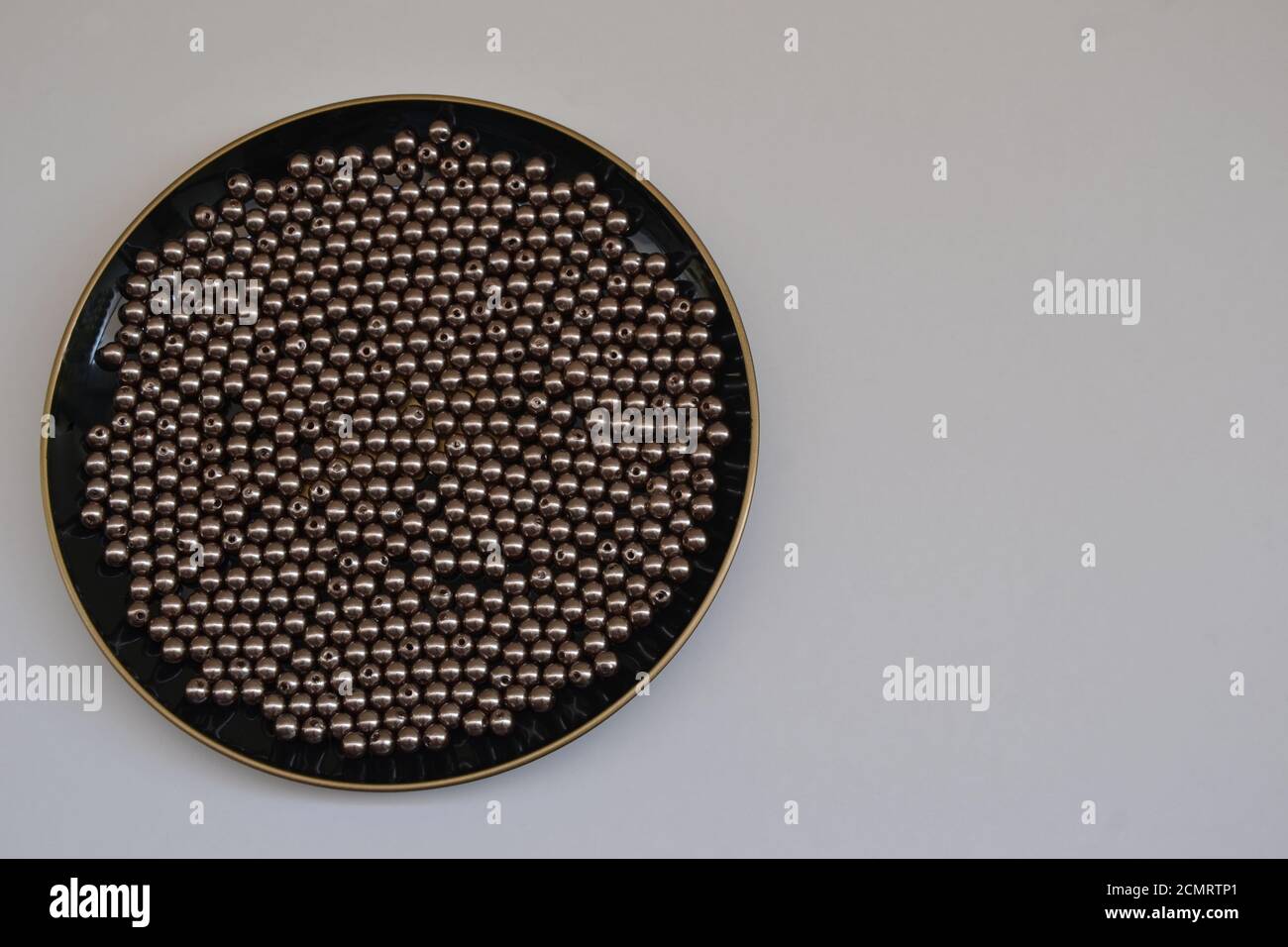 Teller, Teller in schwarzer Farbe mit Perlen oder runder Schmuck in Silber, auf weißem Hintergrund mit Kopierfläche, Brasilien, Südamerika Stockfoto