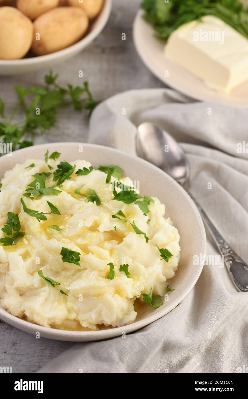 Eine Platte mit Kartoffelpüree mit zerlassener Butter übergossen und gewürzt mit grünen Stockfoto