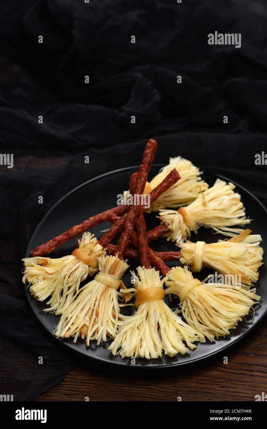 Hexen Besen der suluguni geräucherter Käse und Salami. Ursprüngliche Idee Halloween Snack. Stockfoto