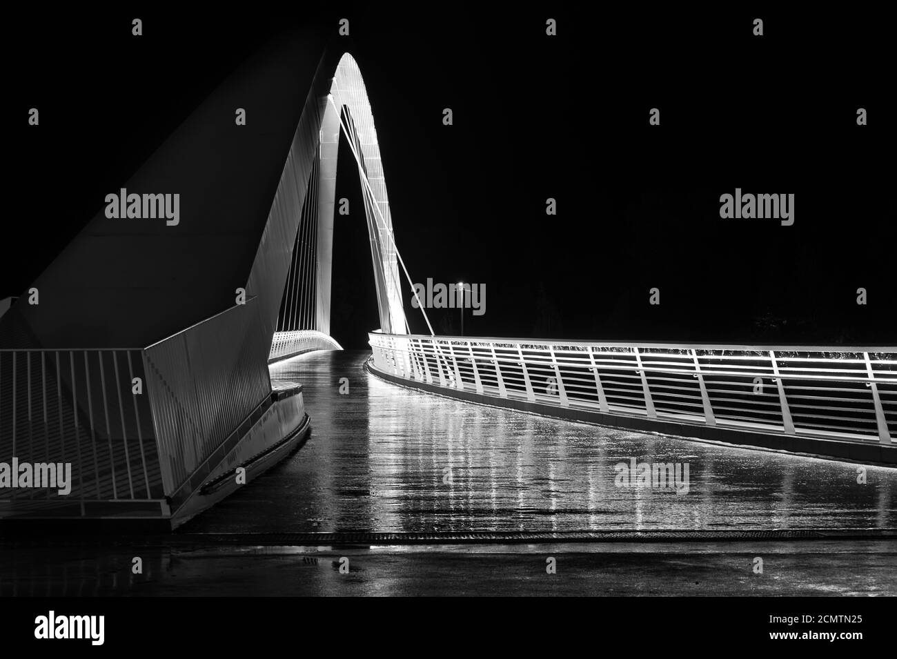 Helsinki / Finnland - 29. August 2020: Eine beleuchtete Wanderbrücke, fotografiert während der Nacht an einem regnerischen Tag. Stockfoto