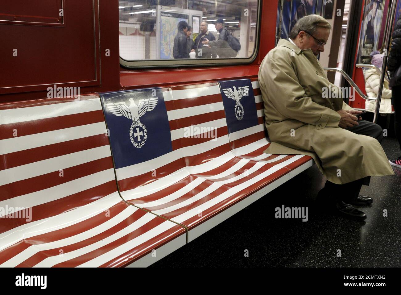 Passagiere fahren einen 42nd Street Shuttle U-Bahn-Zug, verpackt mit  Werbung für die Amazon-Serie "The man in the High Castle", in Manhattan,  New York, 24. November 2015. Der Bürgermeister von New York, Bill