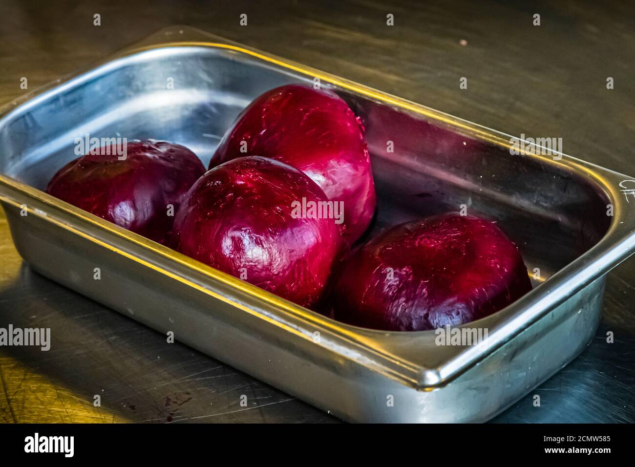 Wie bereitet man Rote Bete richtig zu? Vier geschälte, gekochte Rote Bete liegen in einem Edelstahlblech bei der MakiFood Cookery School/Culinary Institute of Europe in Budapest, Ungarn. Stockfoto