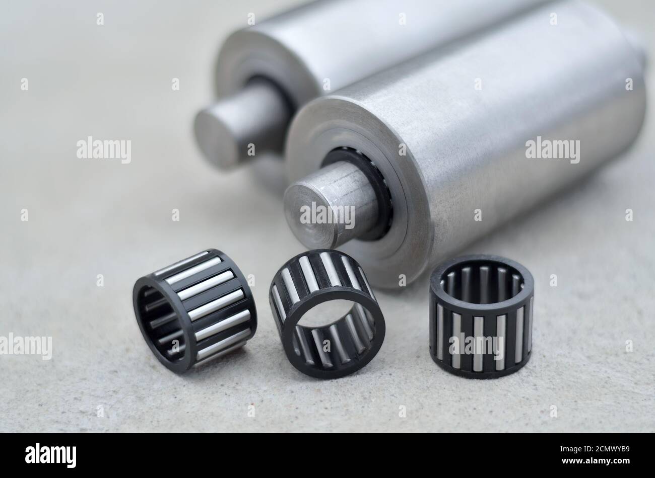 Nadellager in einem Kunststoffabscheider und Metallwellen auf grauem Betonhintergrund, selektiver Fokus. Industriekonzept Stockfoto