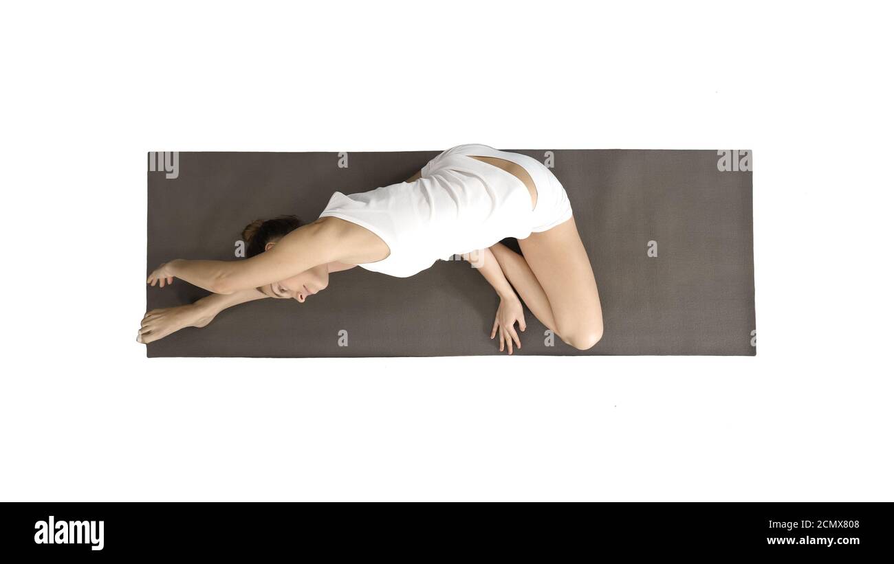 Schöne junge Frau trägt weiße Kleidung tun Yoga-Übung sitzen in einbeinigen King Pigeon (Single Pigeon) Pose auf weißem Hintergrund. Stockfoto