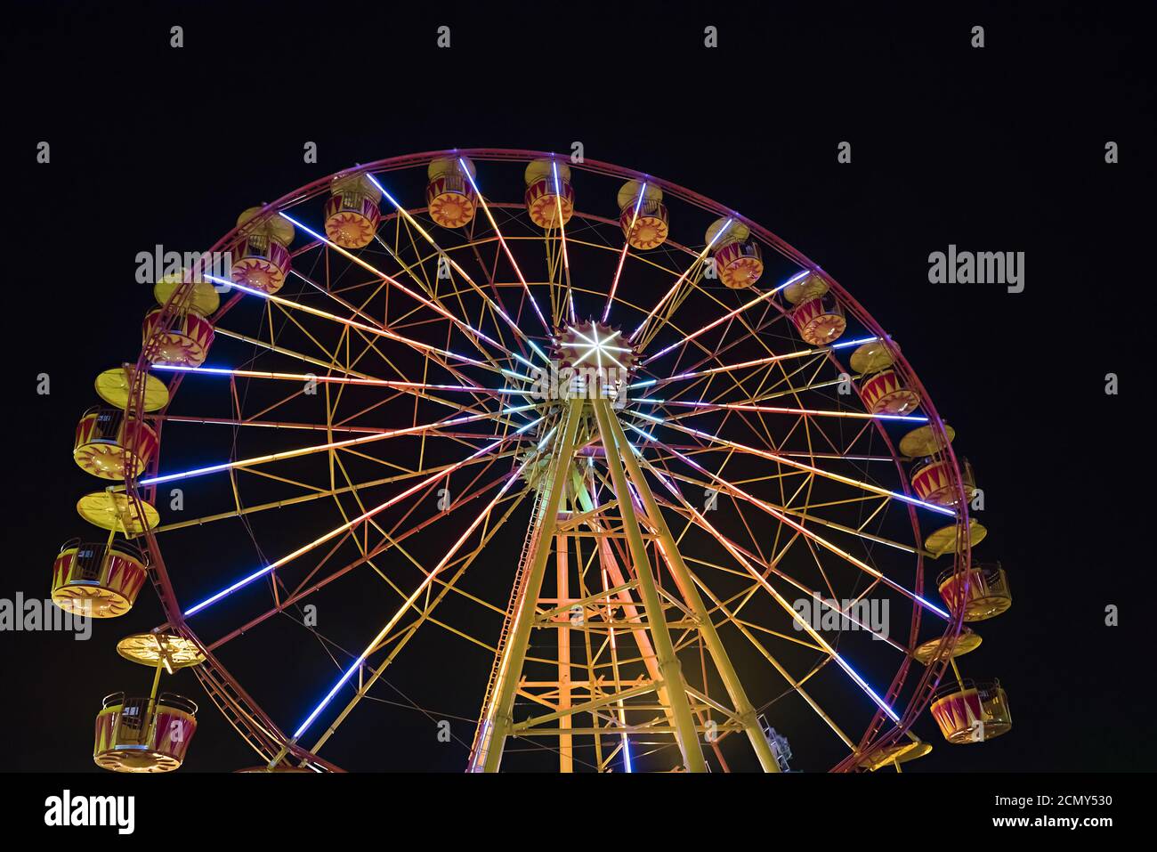 Riesenrad mit leuchtet die Hintergrundbeleuchtung den Nachthimmel. Stockfoto