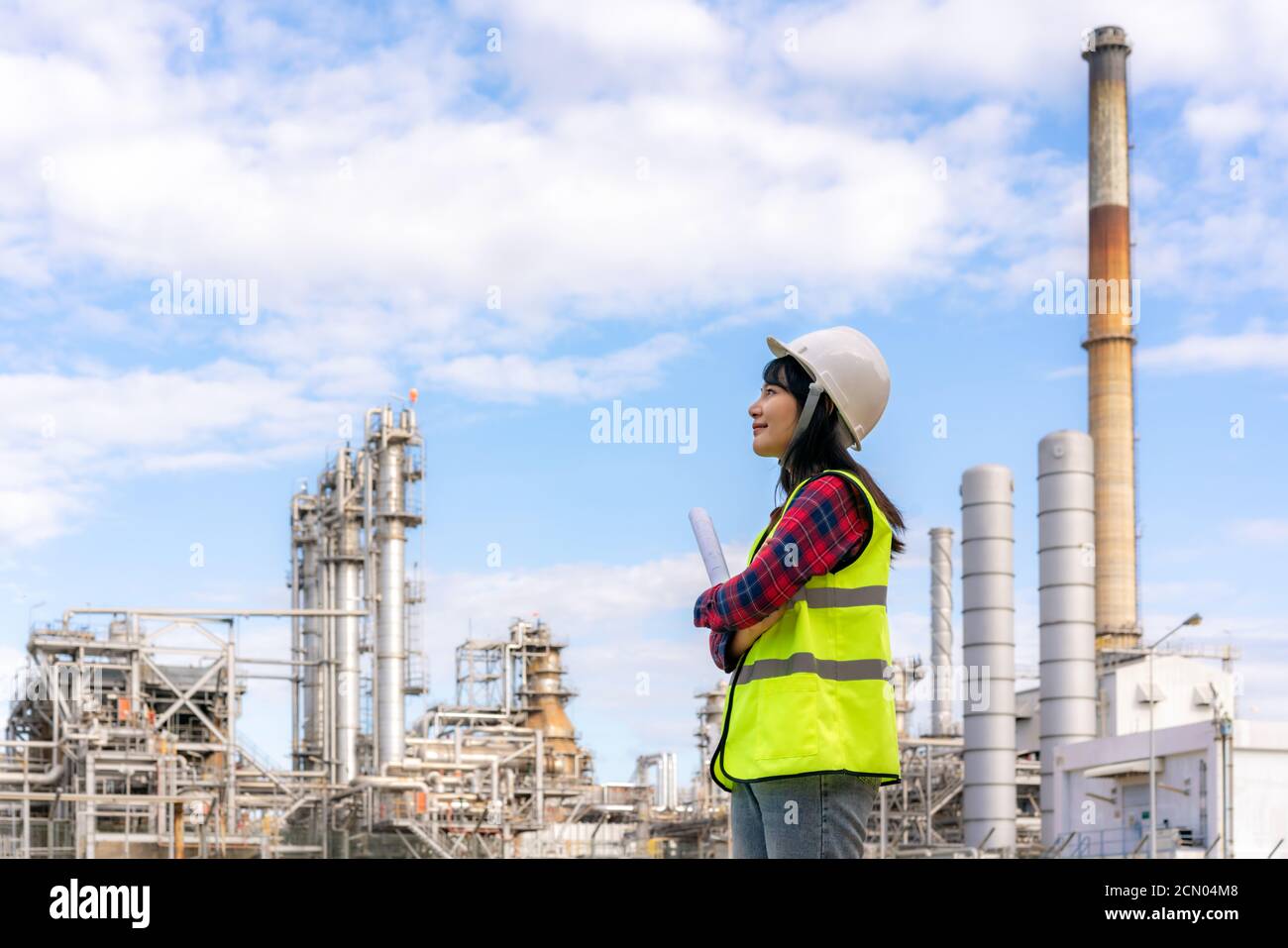 Asiatische Frau Ingenieur Arbeitskontrolle in Kraftwerk Energiewirtschaft Herstellung Öl Raffinerie. Engineering-Check-Anlage mit Blaupause. Stockfoto