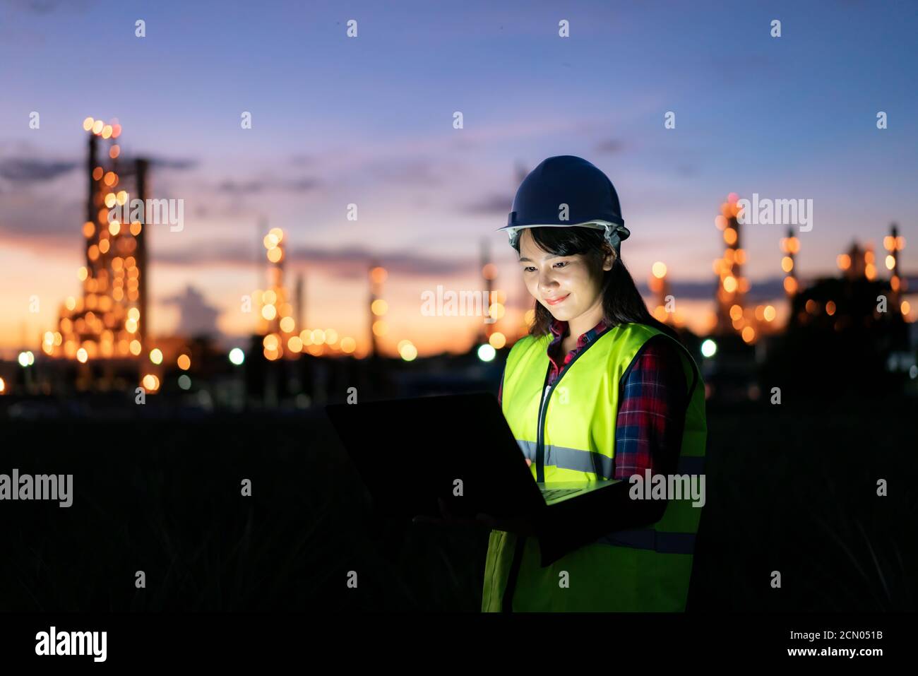Asiatische Frau petrochemische Ingenieur arbeiten bei Nacht mit Notebook im Inneren Öl-und Gasraffinerie-Anlage Industrie Fabrik in der Nacht für inspector Sicherheit qua Stockfoto