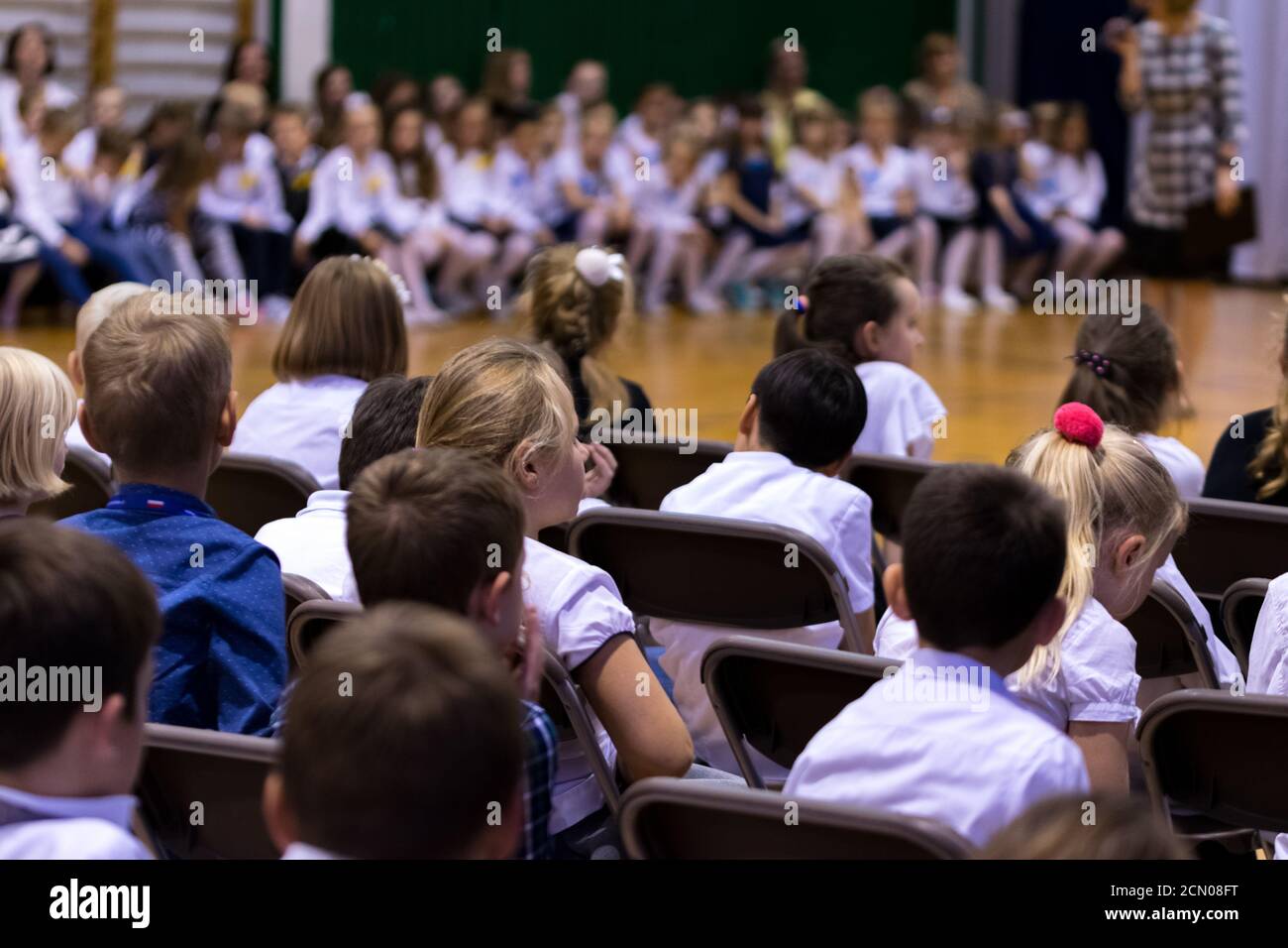 Legionowo, Polen - 25. Oktober 2019: Beginn des Schuljahres. Schüler, Eltern und Lehrer in der Turnhalle während der Schulfeier. Kinder in Form Stockfoto