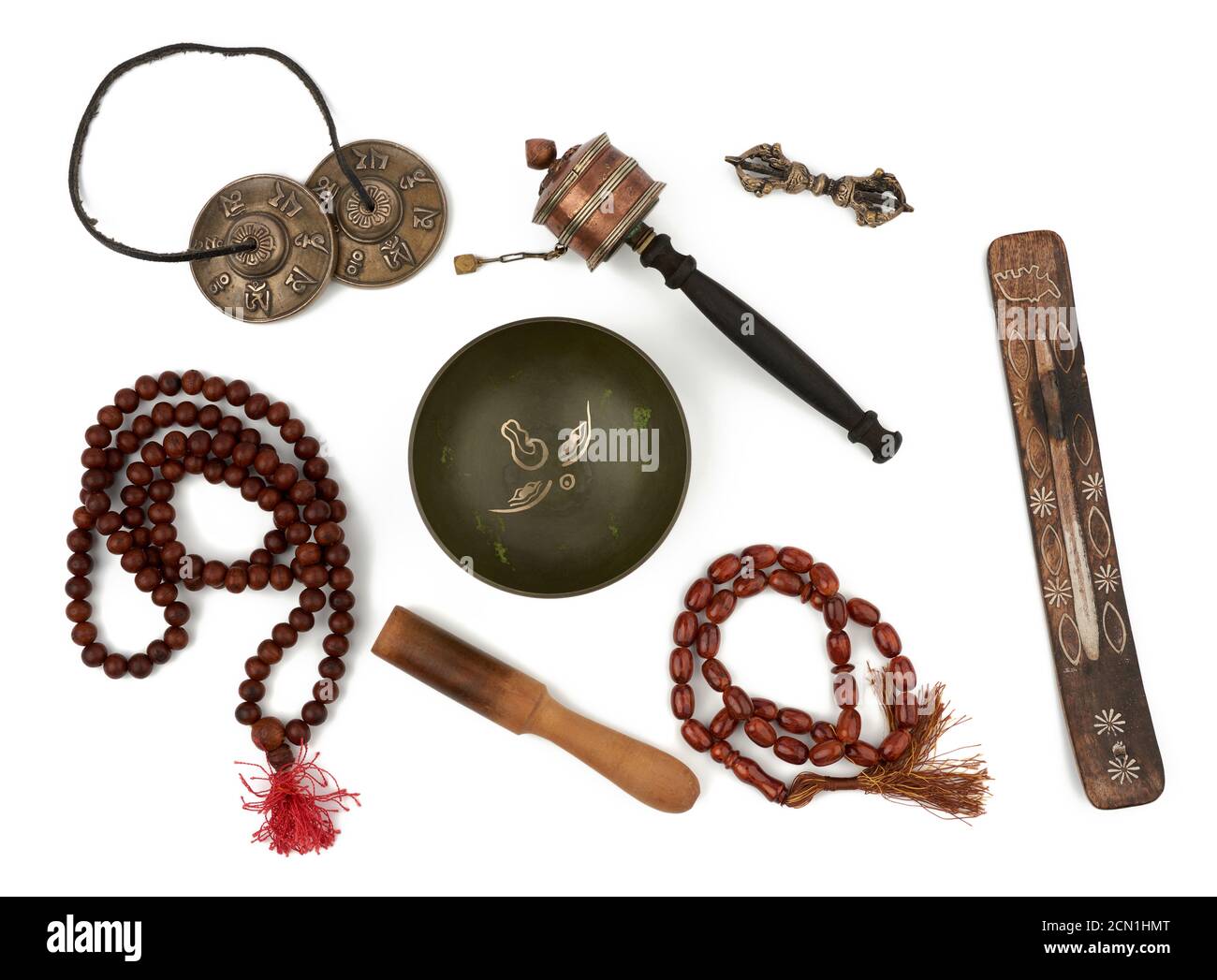 Kupferne Klangschale, Rosenkranz, Gebetstrommel, Strafmittel, Räucherstäbchen und Holzklatsche Stockfoto