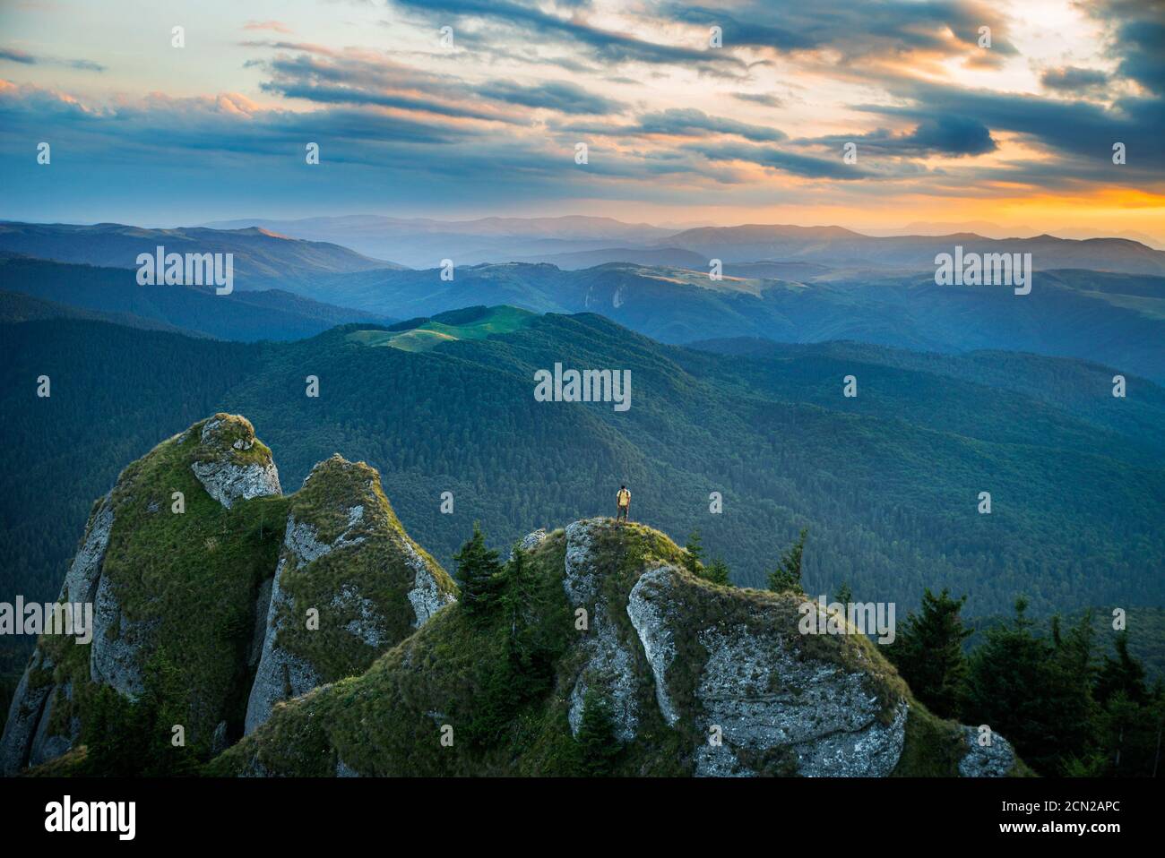 Mann, der am Rande einer Klippe mit erstaunlich steht Hintergrund Stockfoto