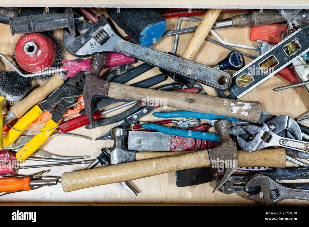 Draufsicht auf verschiedene gut benutzte Handwerkzeuge in Arbeitsplatz Stockfoto