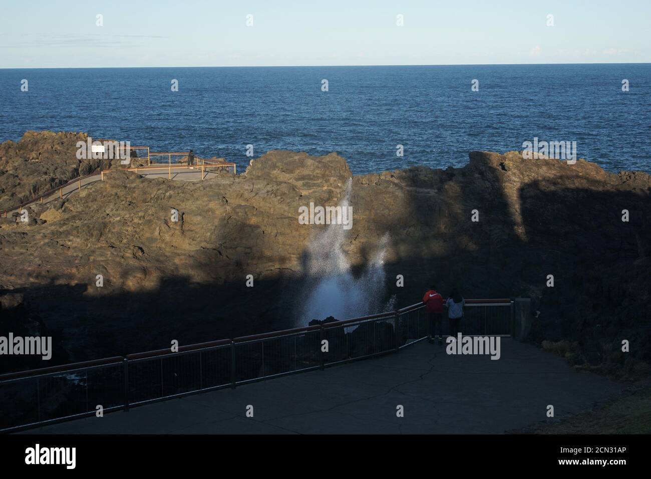 Leute am Kiama Blowhole am späten Nachmittag Stockfoto