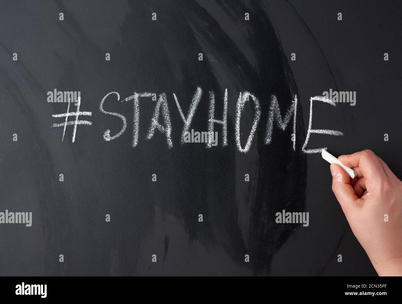 Inschrift zu Hause bleiben in Kreide mit einem Hashtag auf einem Schwarzes Kreidetafel Stockfoto