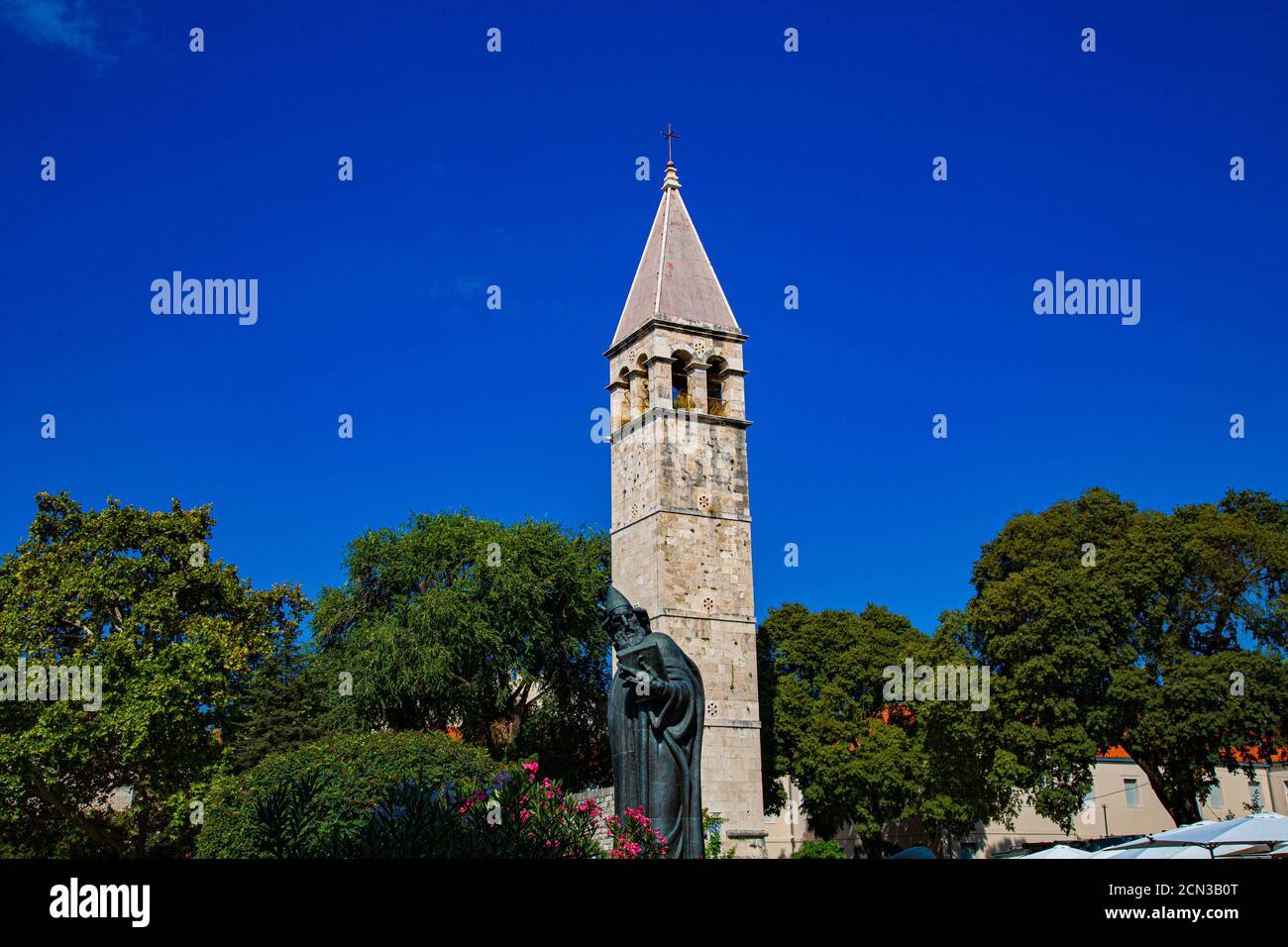 Bronzestatue mit gewölbtem Glockenturm und spitzen Dach Stockfoto