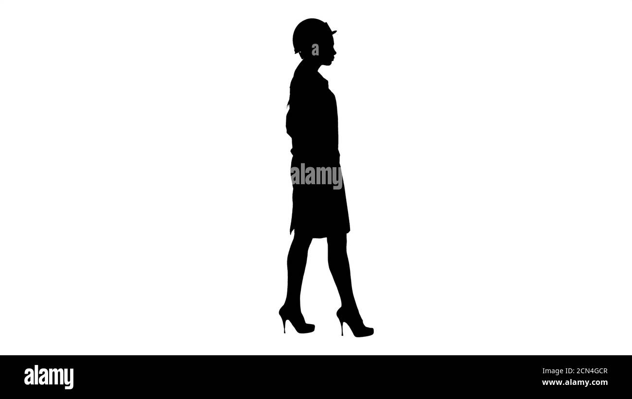 Silhouette Frau in weißem Gewand setzen Hut auf, während Gehen Stockfoto
