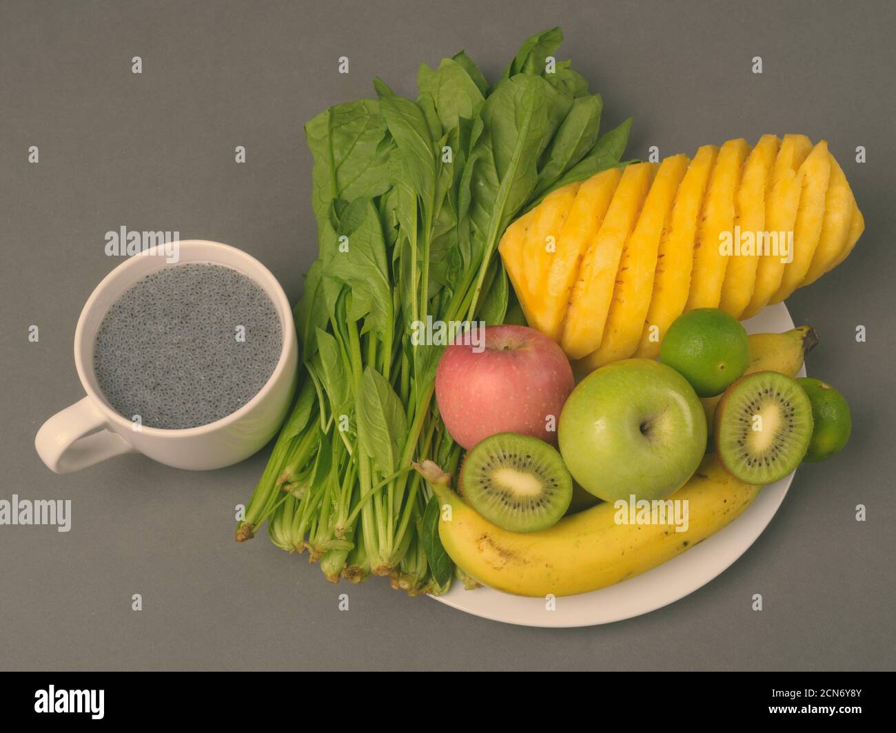 Frisches Obst und Gemüse auf dem Teller mit Chia Samen auf Becher Stockfoto