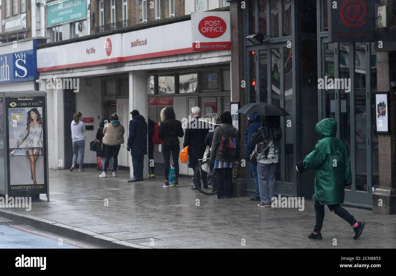 Die Leute warten auf ein Postamt in der Clapham High Street, während die Ausbreitung der Coronavirus-Krankheit (COVID-19) weiter geht, London, Großbritannien, 30. März 2020. REUTERS/Dylan Martinez Stockfoto
