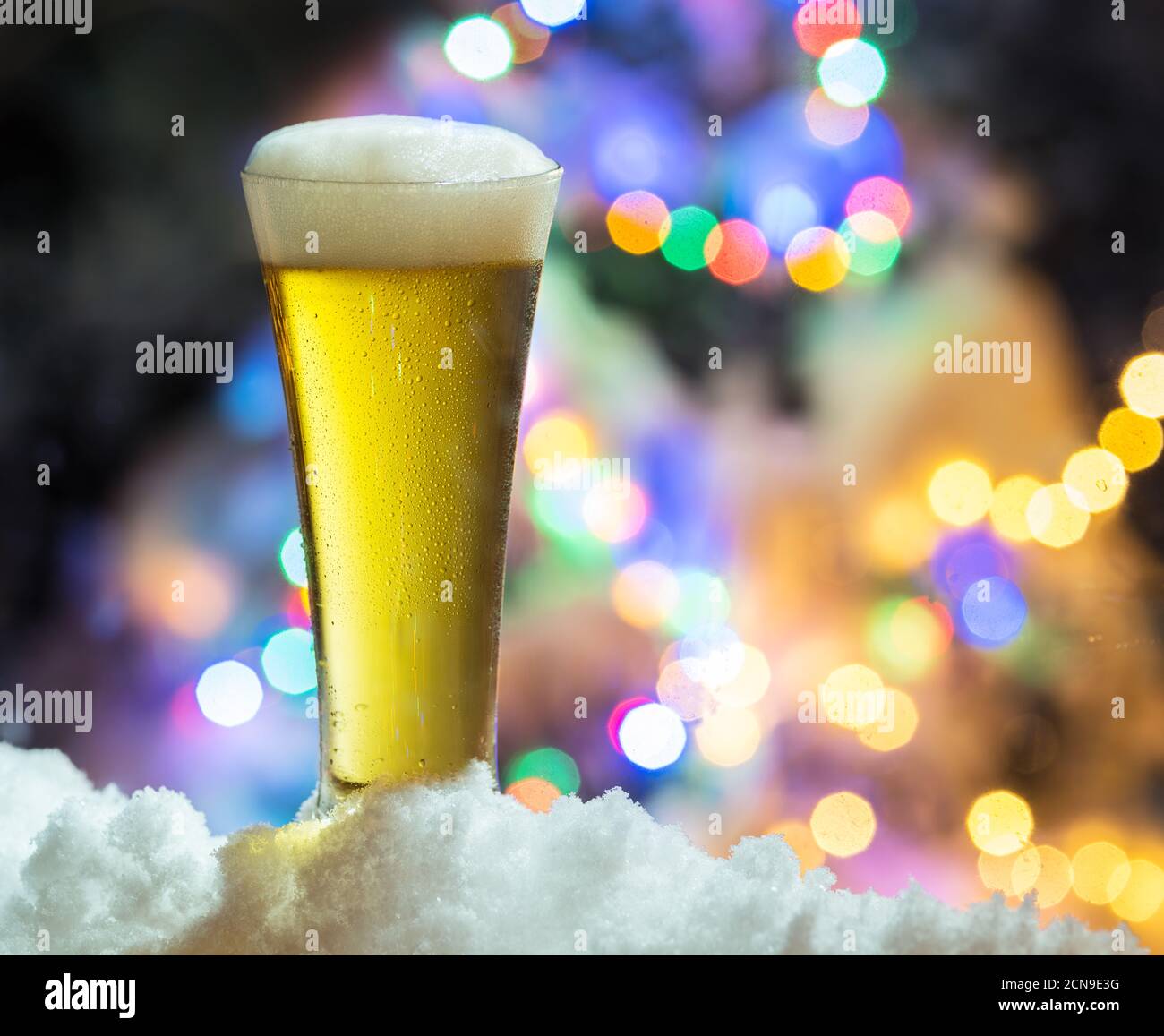 Glas Bier mit Magic Christmas lights im Hintergrund. Stockfoto