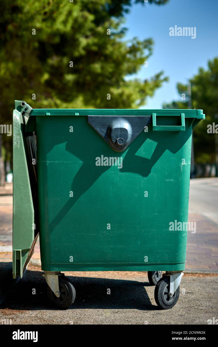 Detail eines leeren grünen Müllbehälters auf der Straße Stockfoto