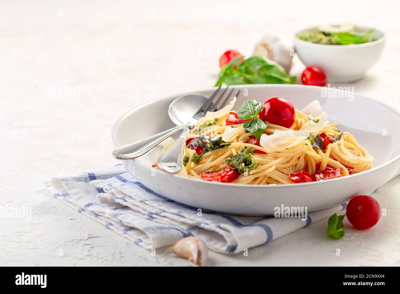 Spaghetti mit Pesto-Sauce, frischem Basilikum und Kirschtomaten. Stockfoto