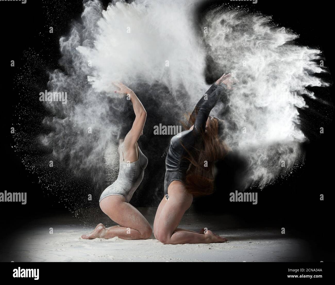 Zwei schöne junge kaukasische Frauen in schwarzen Bodysuits mit einem Sportfigur tanzen ich Stockfoto