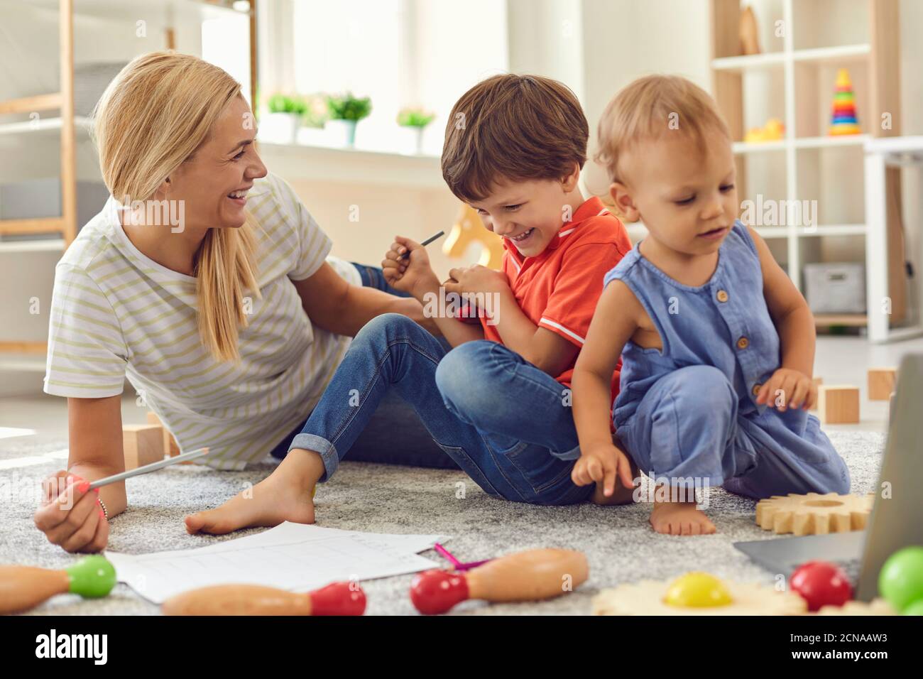 Glückliche Familie Mutter und Kinder sitzen auf dem Boden und spielen Gemeinsam zu Hause Stockfoto