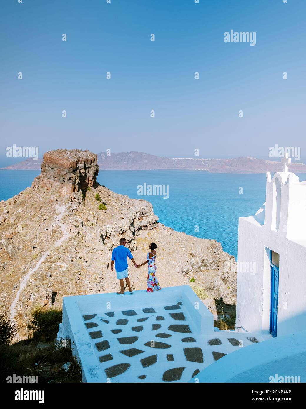 Paar Männer und Frauen im Urlaub Santorini, Blick auf das Meer und den Vulkan von Fira, der Hauptstadt der Insel Santorini in Griechenland Stockfoto