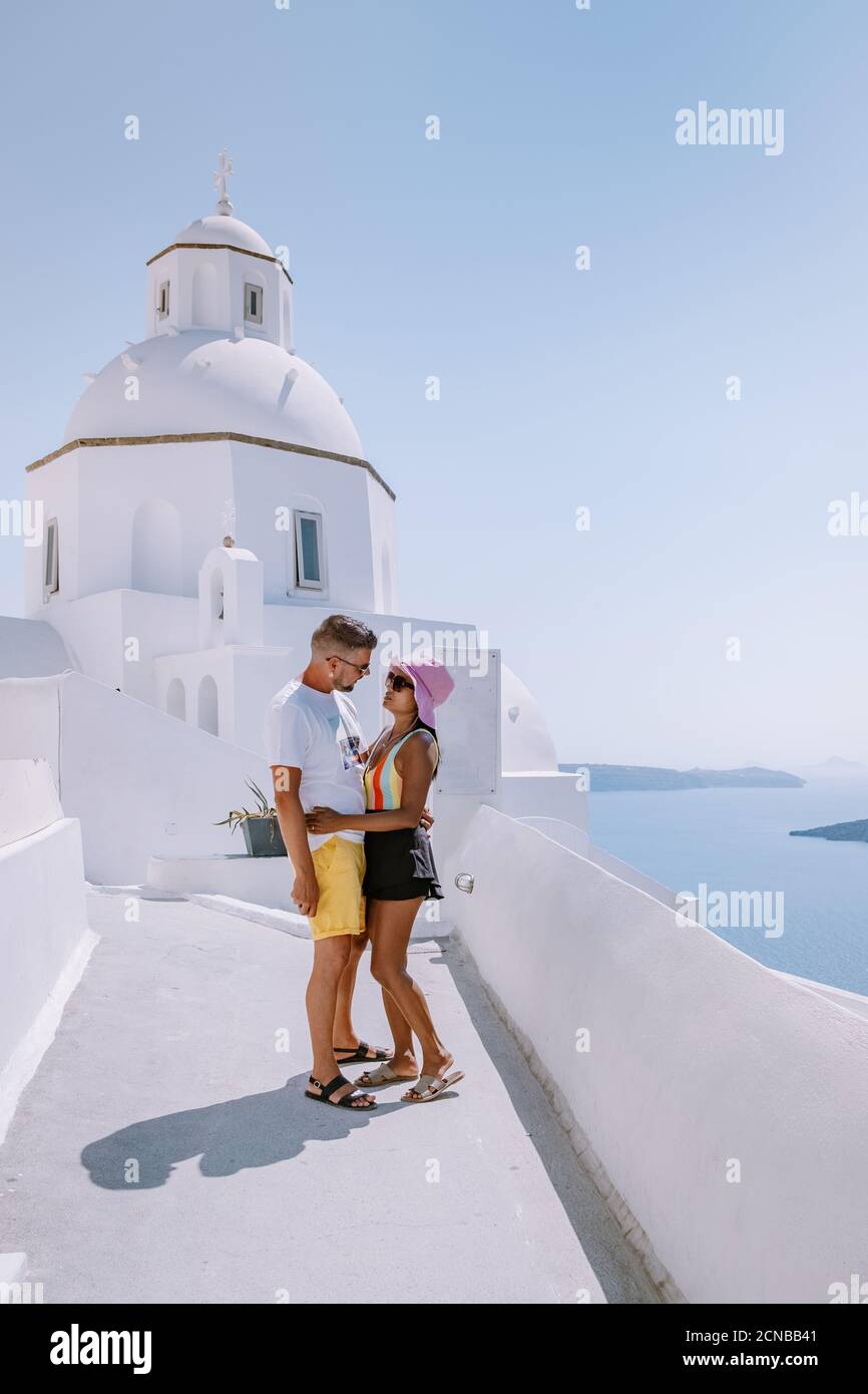 Paar Männer und Frauen im Urlaub Santorini, Blick auf das Meer und den Vulkan von Fira, der Hauptstadt der Insel Santorini in Griechenland Stockfoto