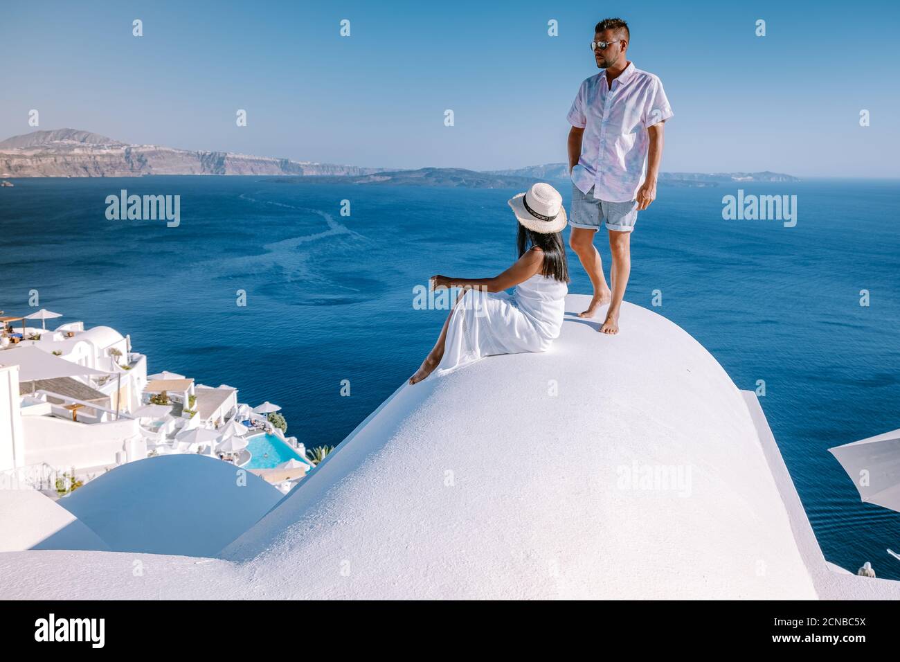 Paar Männer und Frauen im Urlaub Santorini, Blick auf das Meer und den Vulkan von Fira, der Hauptstadt der Insel Santorini in Griechenland Stockfoto