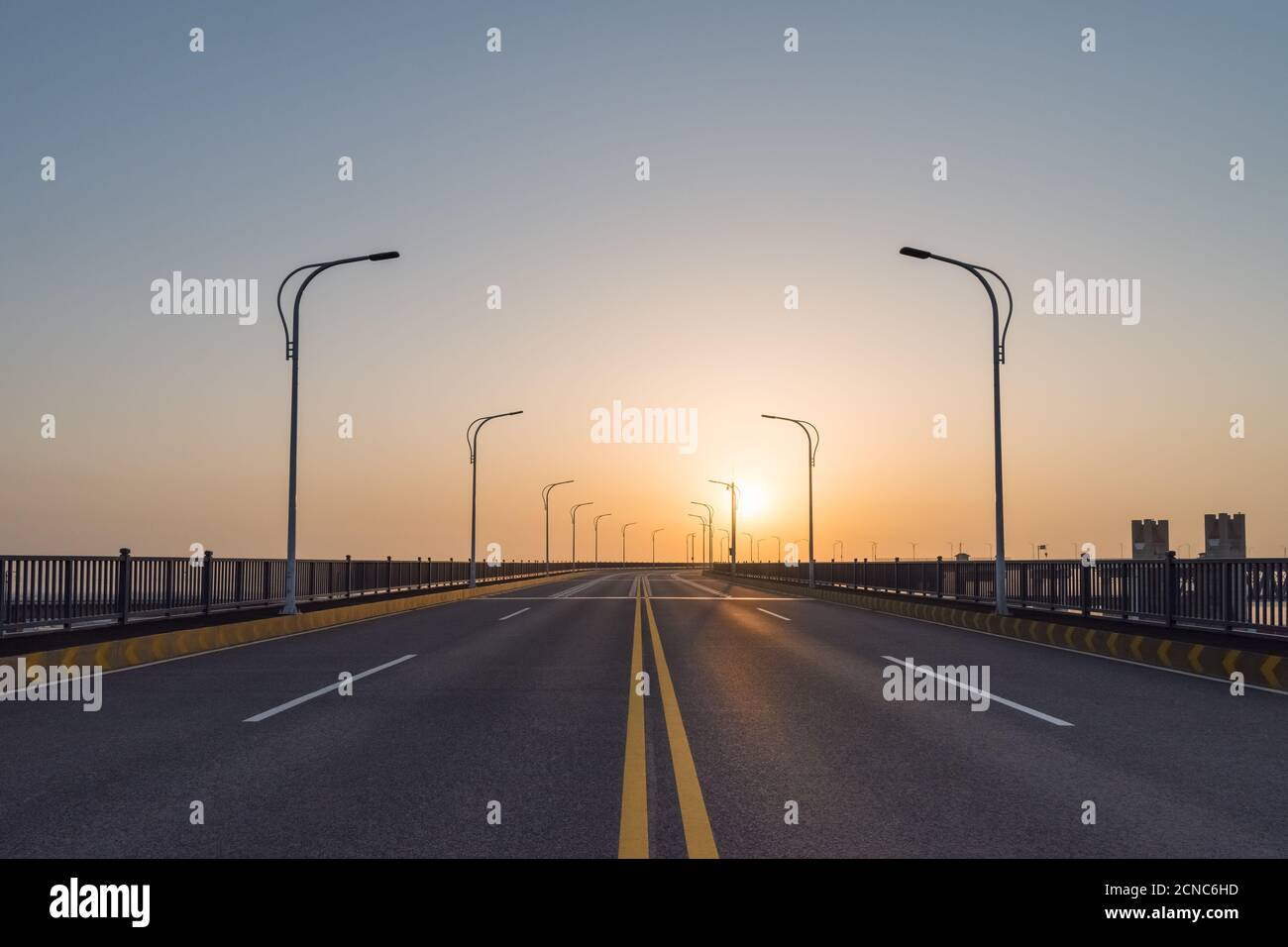 Straße auf Brücke bei Sonnenaufgang Stockfoto