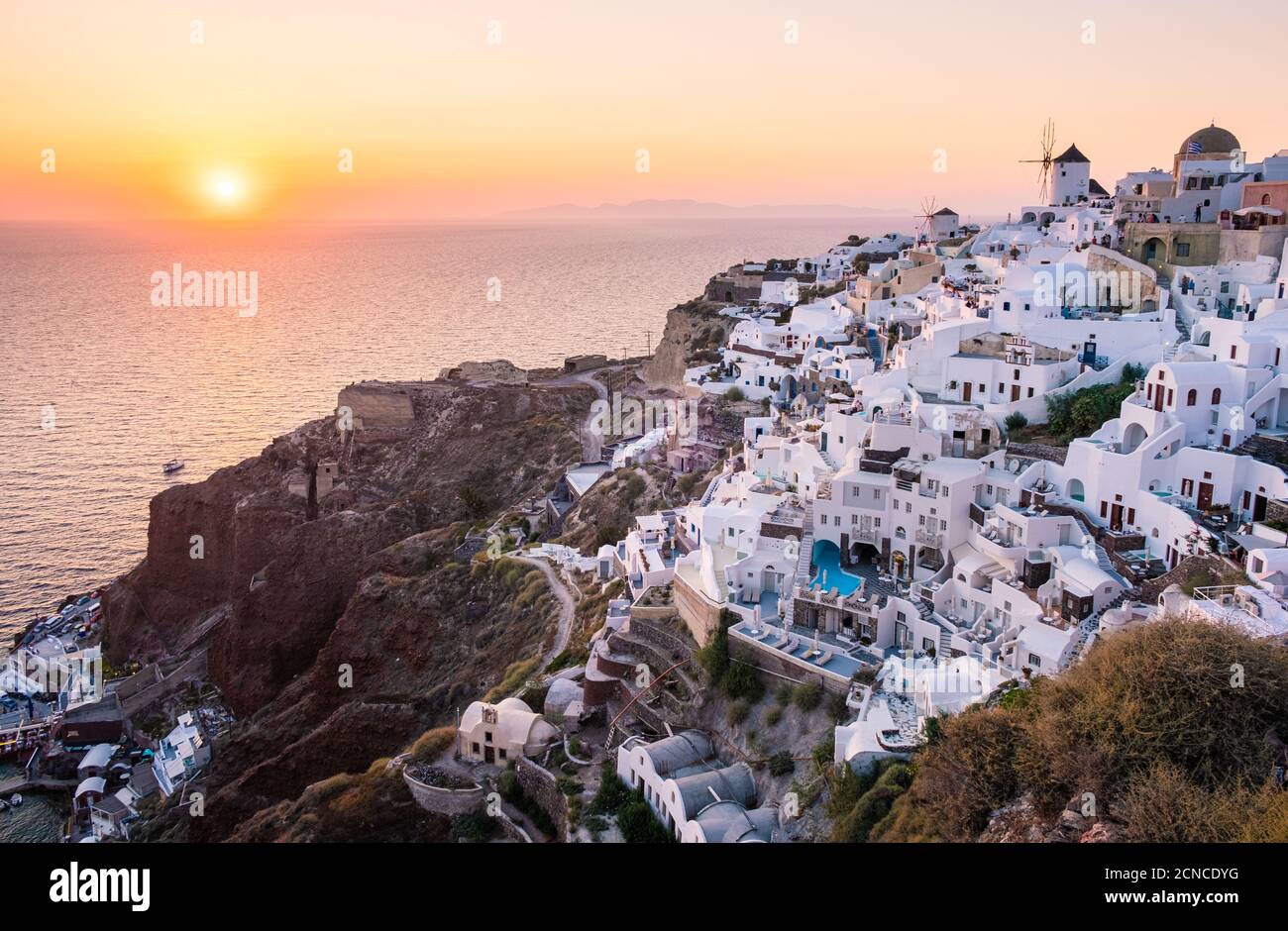 Sonnenuntergang auf der Insel Santorini Griechenland, wunderschönes weiß getünchtes Dorf Oia mit Kirche und Windmühle während des Sonnenuntergangs Stockfoto