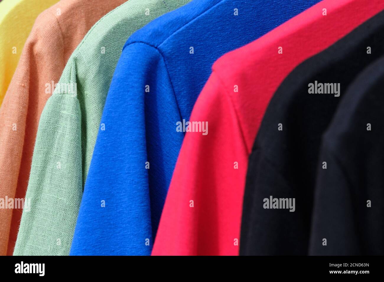 Hängende Tasche mit trendigen bunten Pullovern im Laden. Stockfoto
