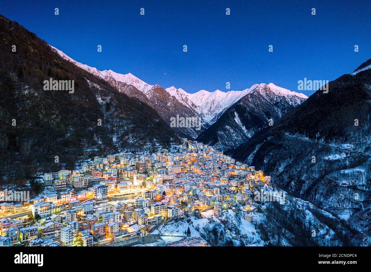 Blick per Drohne der Winterdämmerung über dem beleuchteten Dorf Premana, Valsassina, Provinz Lecco, Lombardei, Italien, Europa Stockfoto