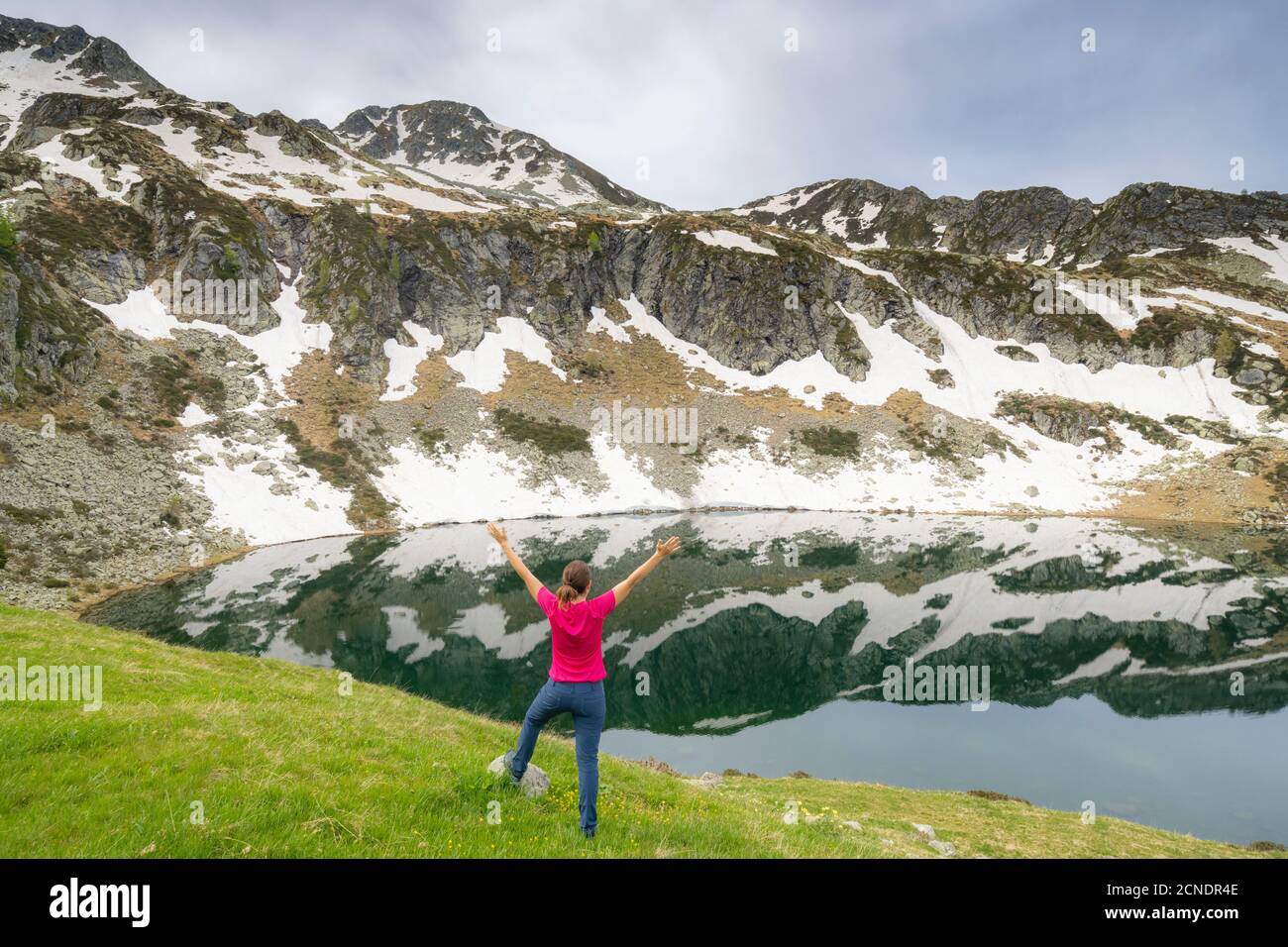 Fröhliche Frau mit ausgestreckten Armen an den Ufern der Porcile Seen, Tartano-Tal, Valtellina, Lombardei, Italien, Europa Stockfoto